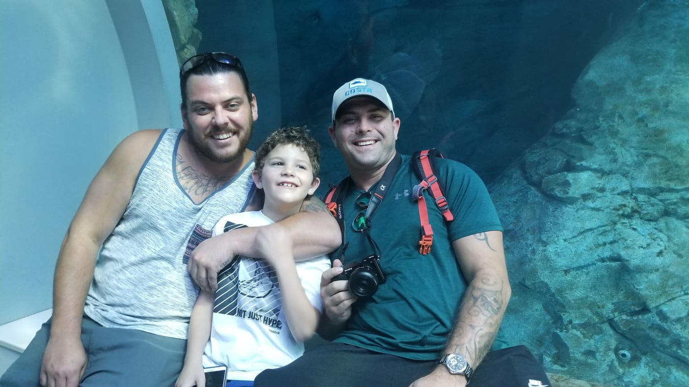 Bradley Medel smiling with family at an aquarium